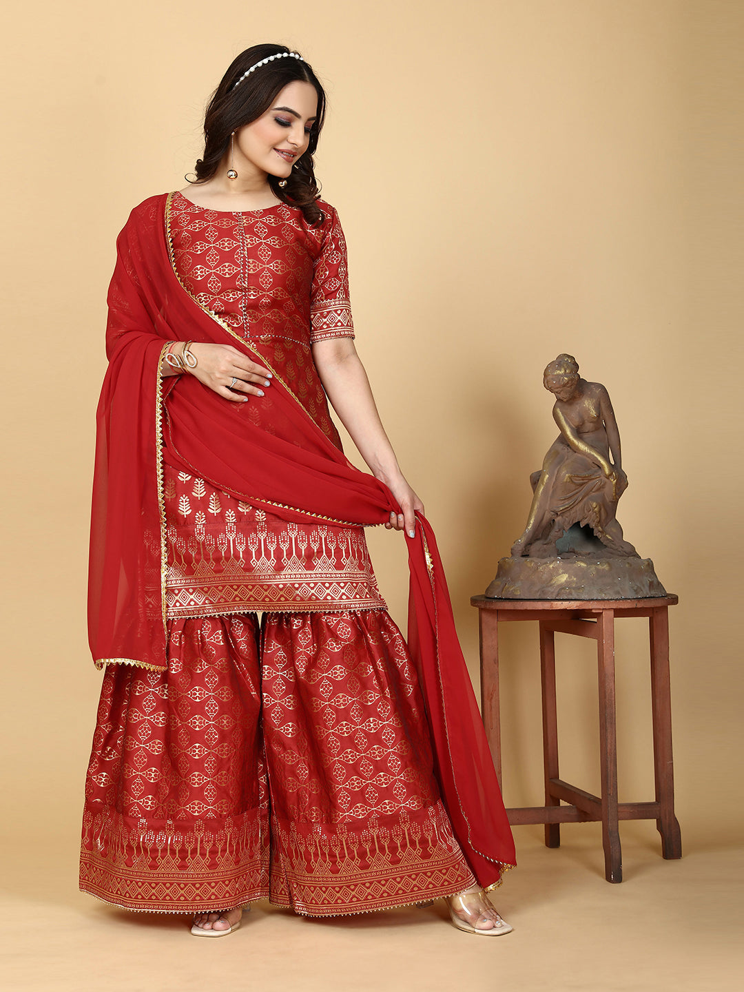 A traditional ensemble featuring a woven kurta adorned with ethnic motifs, complemented by flowing sharara pants and a matching dupatta