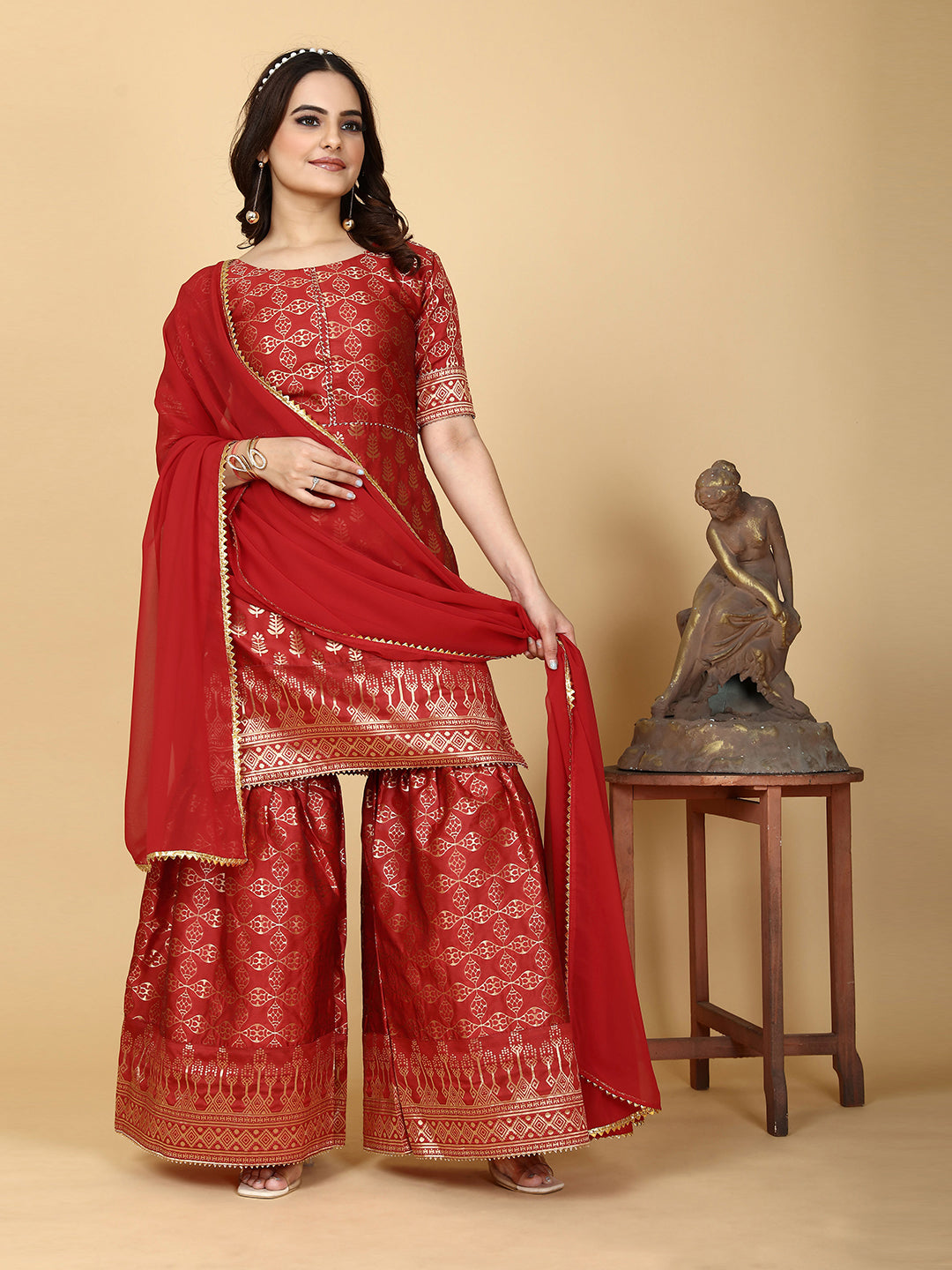 A traditional ensemble featuring a woven kurta adorned with ethnic motifs, complemented by flowing sharara pants and a matching dupatta