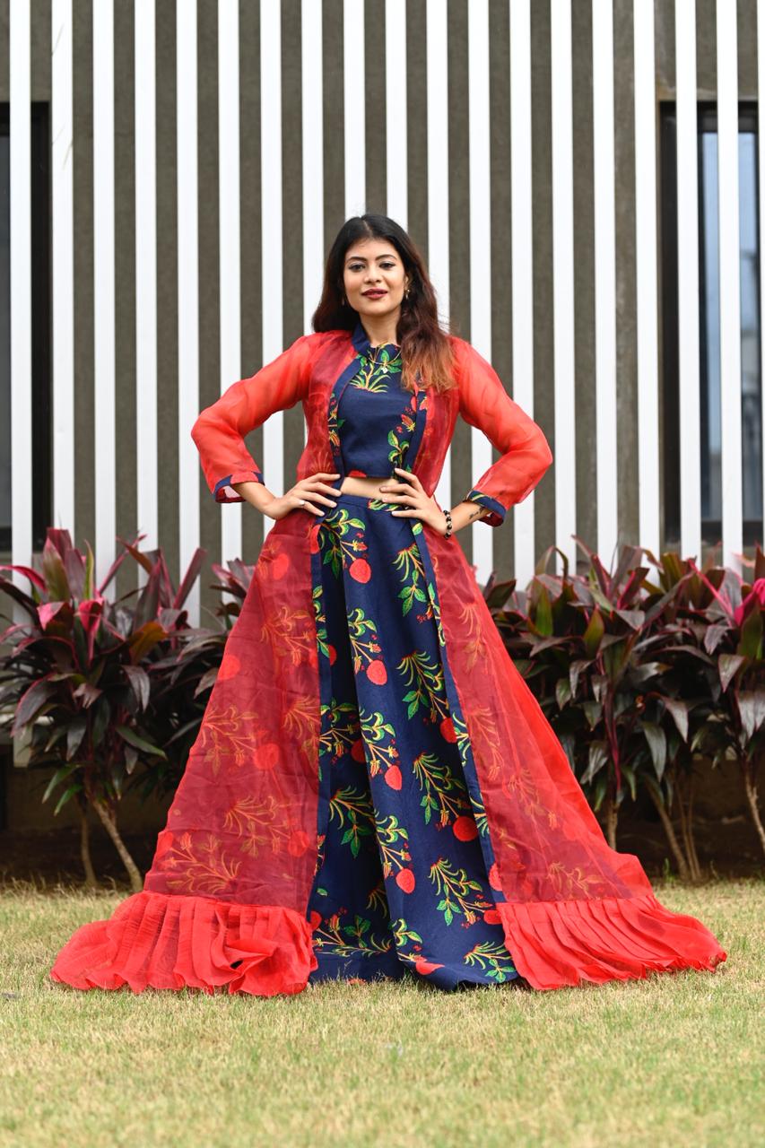 A vibrant party wear lehenga choli featuring a colorful floral cotton skirt and a flowy net dupatta.
