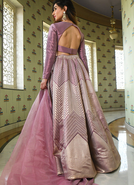 A lavender partywear lehenga choli set woven with intricate Zari Jacquard work.