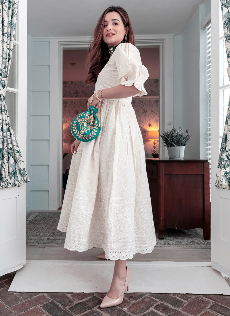 A breezy off-white maxi dress adorned with delicate floral embroidery, perfect for a summery look.