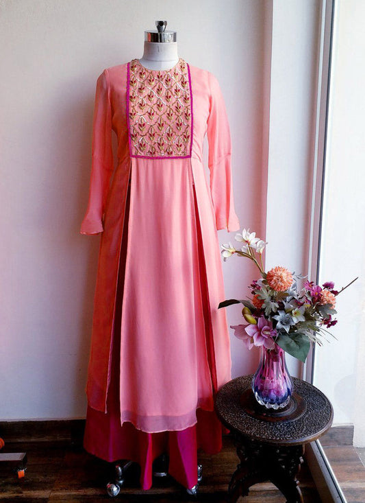Peach colored faux georgette designer suit with embroidered details and a contrasting tapeta silk ghera 