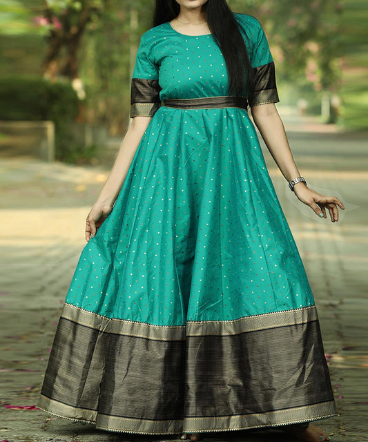 Graceful Rama green colored festive wear gown crafted from woven Tapetta silk, perfect for celebratory occasions.