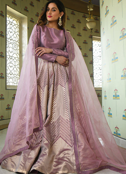 A lavender partywear lehenga choli set woven with intricate Zari Jacquard work.