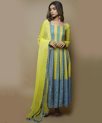 A model wearing a Medha Rayon Chikankari Suit Set, featuring intricate white embroidery on a vibrant, flowing fabric, paired with matching pants and a dupatta.