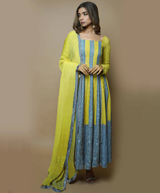 A model wearing a Medha Rayon Chikankari Suit Set, featuring intricate white embroidery on a vibrant, flowing fabric, paired with matching pants and a dupatta.